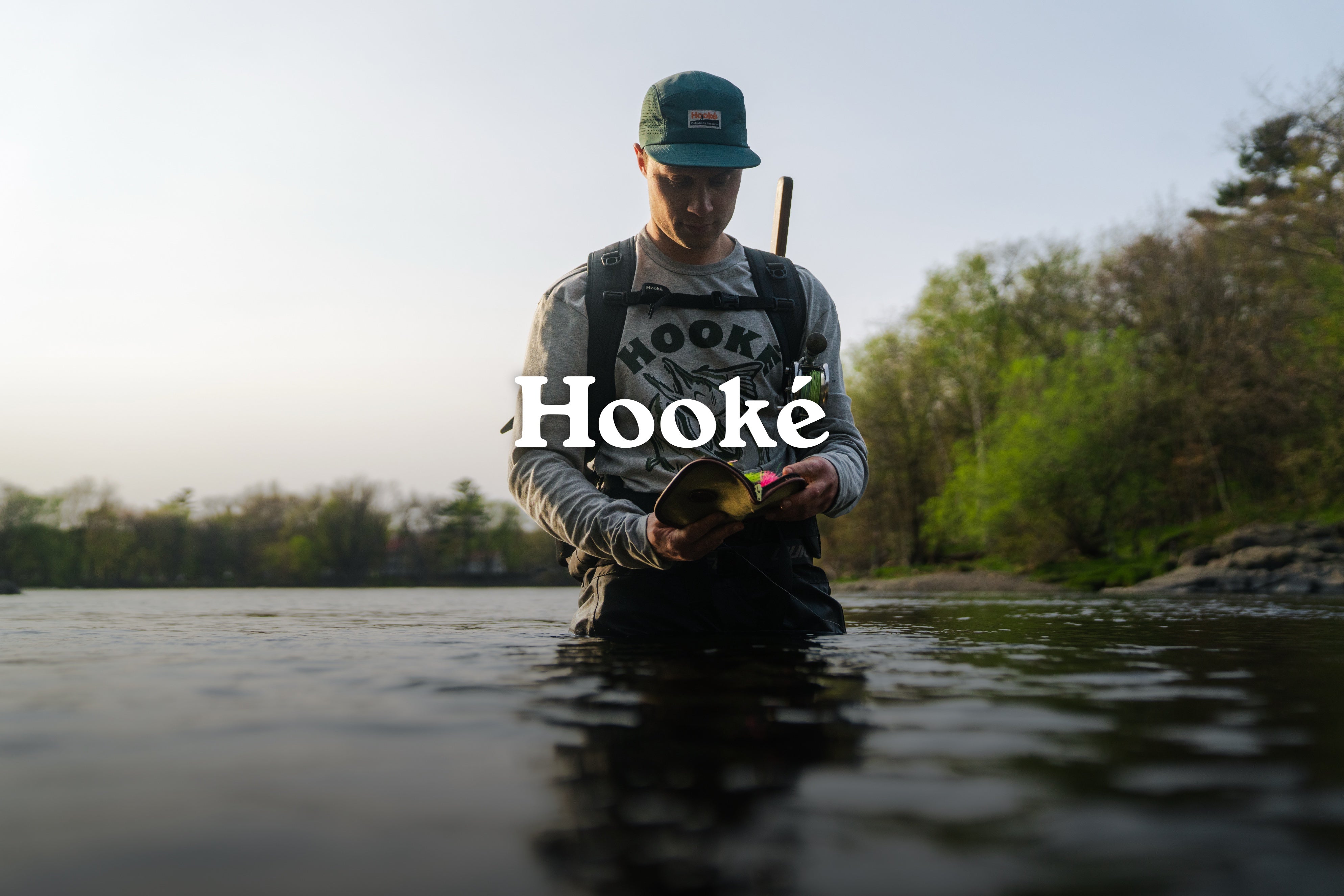 Man wearing Hooké gear while standing in a lake fishing