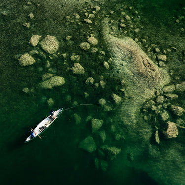 Canoe on a river with greenery and rocks